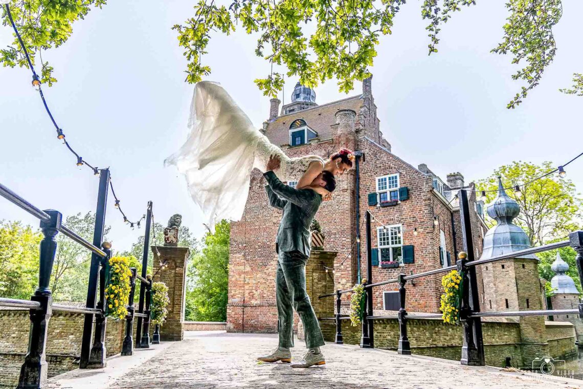 trouwfoto door Robin Looy bruidegom tilt bruid op